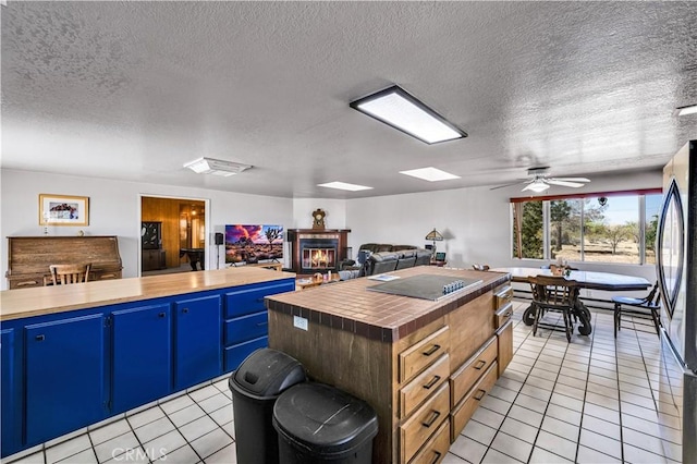 kitchen featuring blue cabinetry, butcher block countertops, and light tile patterned floors