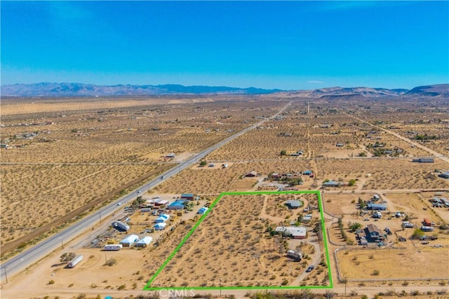 drone / aerial view featuring a mountain view, a rural view, and a desert view