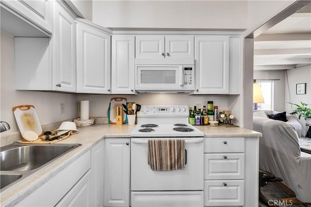 kitchen with white cabinets, white appliances, and a sink