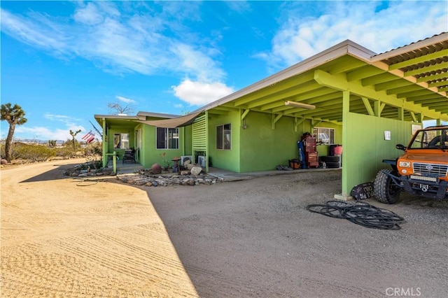 exterior space with a carport and dirt driveway