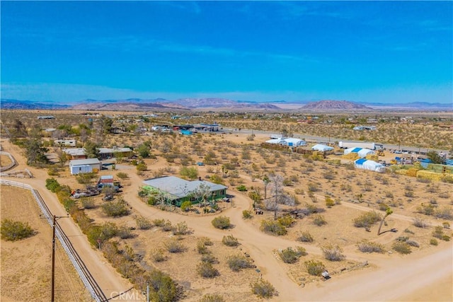 drone / aerial view featuring a mountain view and view of desert