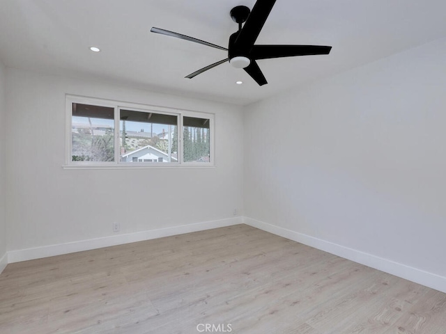 empty room with recessed lighting, light wood-style flooring, a ceiling fan, and baseboards