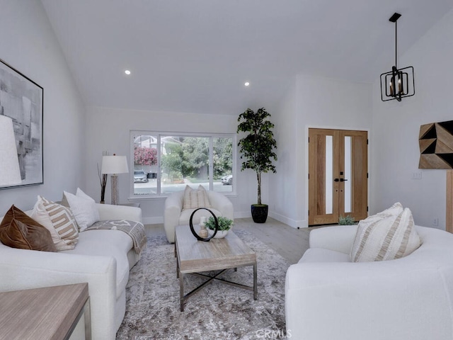 living area featuring vaulted ceiling, baseboards, recessed lighting, and a chandelier