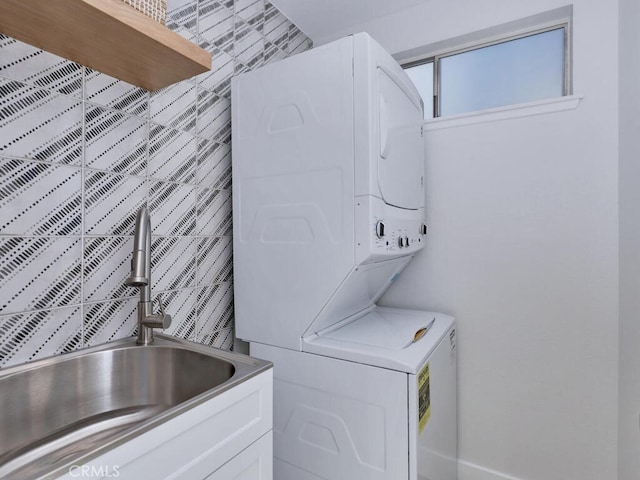 laundry area featuring a sink, stacked washing maching and dryer, and laundry area