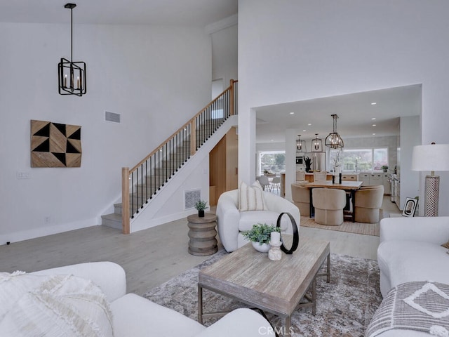 living area with visible vents, wood finished floors, and stairway