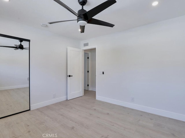 unfurnished bedroom with baseboards, wood finished floors, and visible vents