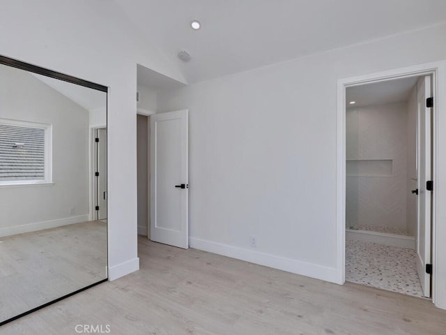 unfurnished bedroom featuring recessed lighting, vaulted ceiling, wood finished floors, and baseboards