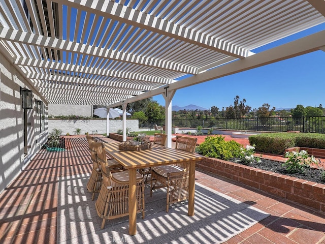 view of patio with a pergola, outdoor dining area, fence, and a mountain view