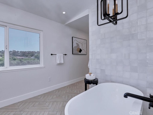 full bathroom featuring baseboards, a soaking tub, and recessed lighting