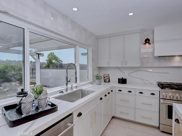 kitchen with white cabinets, a healthy amount of sunlight, stainless steel appliances, and a sink