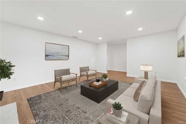 living area featuring recessed lighting, visible vents, and wood finished floors