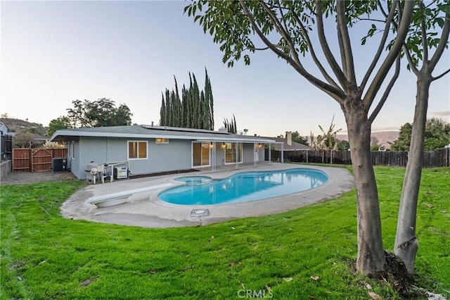 view of swimming pool featuring a fenced in pool, a yard, a patio area, and a fenced backyard