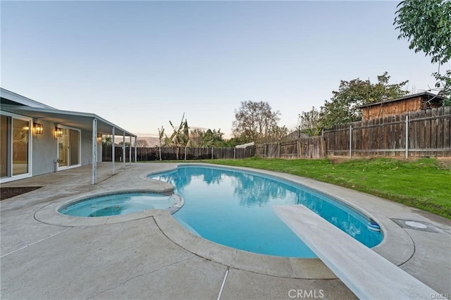 view of pool with a patio, a diving board, a fenced in pool, a fenced backyard, and an in ground hot tub