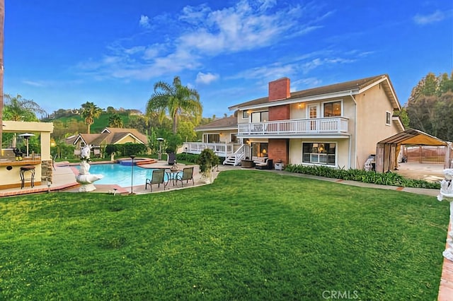 25641 Rapid Falls Rd, Laguna Hills, CA 92653 - back of property with an outdoor pool, a yard, a chimney, stucco siding, and a detached carport