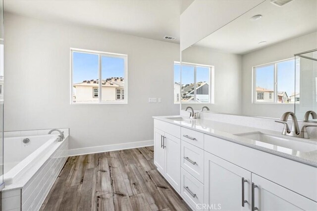 16669 Dara Ave, Chino, CA 91708 - full bath with double vanity, a garden tub, wood finished floors, and a shower with shower door