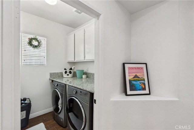 laundry area featuring dark wood-style flooring, visible vents, baseboards, separate washer and dryer, and cabinet space