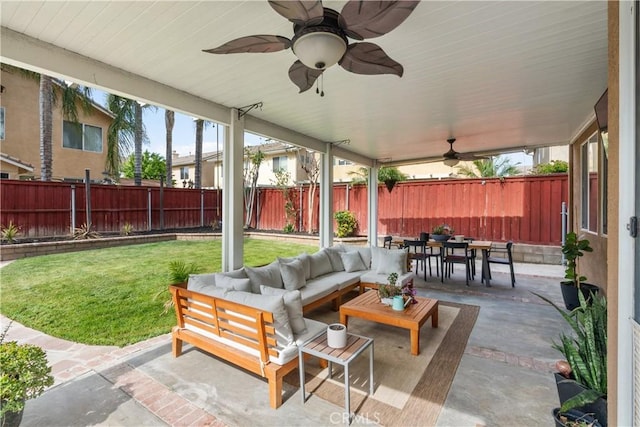 view of patio / terrace featuring a fenced backyard, outdoor dining space, a ceiling fan, and an outdoor hangout area