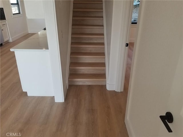 stairway with baseboards and wood finished floors
