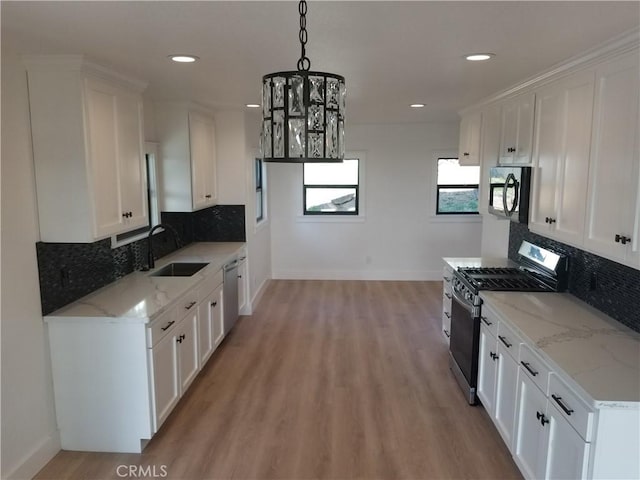 kitchen with baseboards, a sink, white cabinetry, and appliances with stainless steel finishes