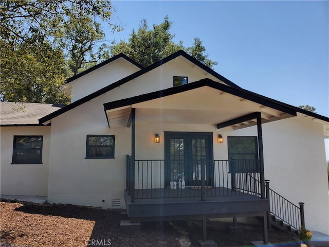 view of front facade with stucco siding, crawl space, a shingled roof, and french doors