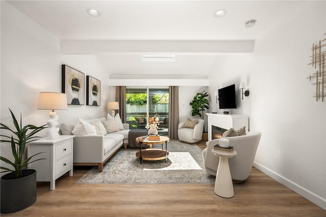 23732 Hillhurst Dr Unit 32, Laguna Niguel, CA 92677 - living area with baseboards, a warm lit fireplace, vaulted ceiling with beams, and light wood-style floors