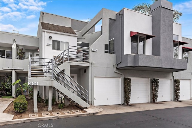 view of building exterior featuring stairs and an attached garage
