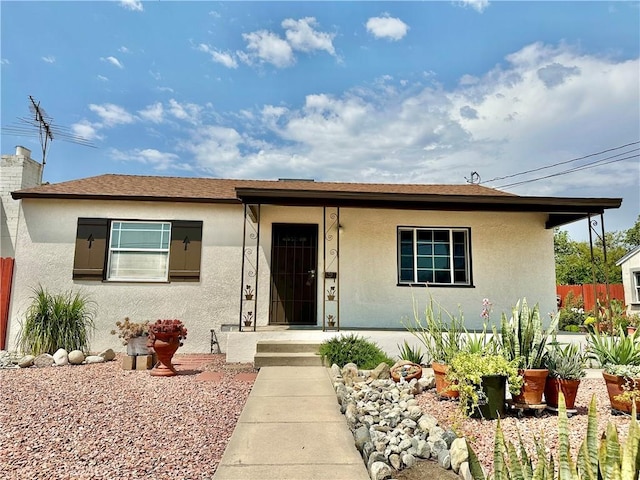 view of front facade featuring fence and stucco siding