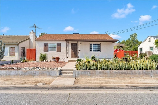 312 W Lugonia Ave, Redlands, CA 92374 - view of front of house with stucco siding, fence, and a chimney
