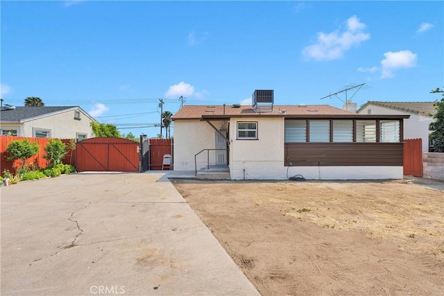 312 W Lugonia Ave, Redlands, CA 92374 - view of front of home with a gate, central air condition unit, stucco siding, and fence