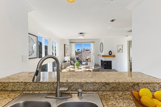 20371 Bluffside Cir Unit B401, Huntington Beach, CA 92646 - kitchen with tile countertops, ornamental molding, a sink, a fireplace, and open floor plan
