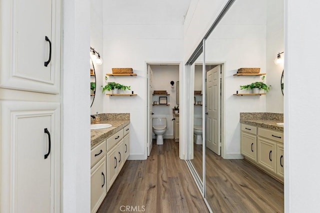 20371 Bluffside Cir Unit B401, Huntington Beach, CA 92646 - full bath featuring two vanities, wood finished floors, toilet, and a sink