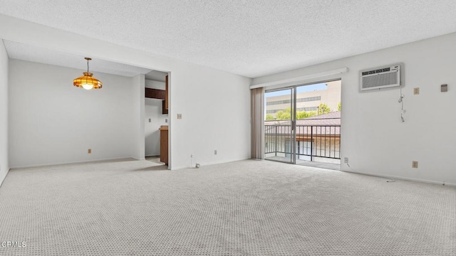 unfurnished living room with a water view, a wall unit AC, a textured ceiling, and carpet flooring