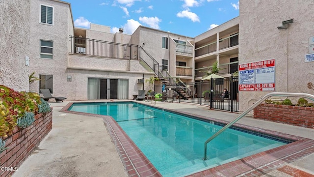 community pool featuring fence and a patio