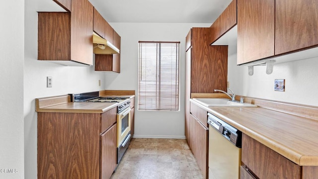 kitchen featuring a sink, stainless steel range with gas stovetop, under cabinet range hood, light countertops, and dishwasher