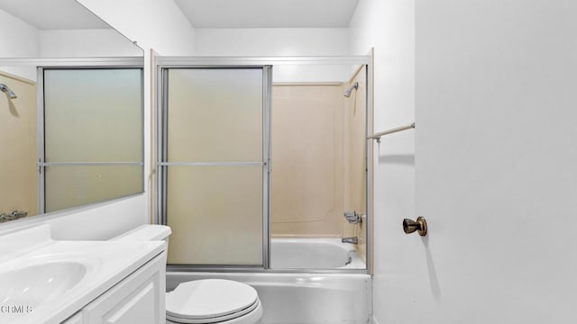 bathroom featuring bath / shower combo with glass door, toilet, and vanity