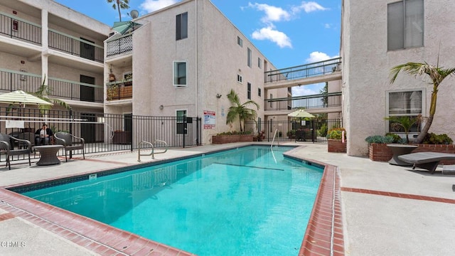 community pool featuring fence and a patio area