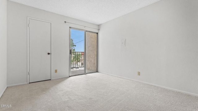 spare room featuring a textured ceiling, baseboards, and carpet floors