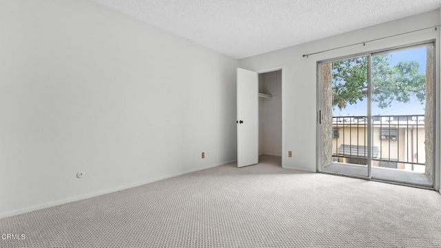 unfurnished bedroom featuring light colored carpet, a closet, access to exterior, baseboards, and a textured ceiling