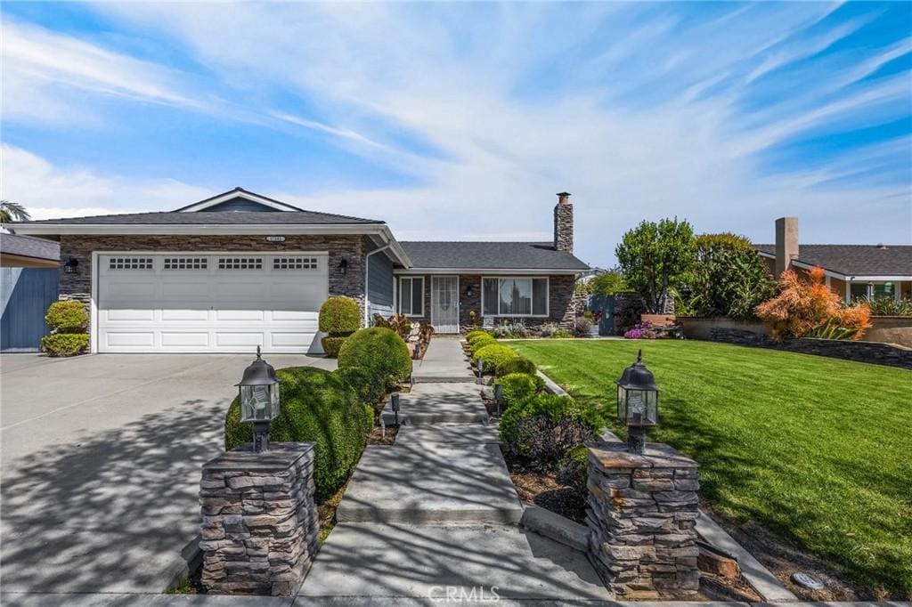 17381 Yorkshire Ave, Yorba Linda, CA 92886 - ranch-style house with a chimney, a garage, driveway, stone siding, and a front yard