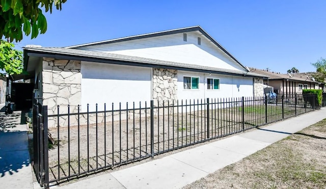 1811 W Glen Ave, Anaheim, CA 92801 - view of side of home featuring stucco siding, fence private yard, and stone siding