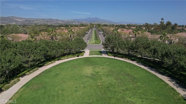 surrounding community with a mountain view and a lawn
