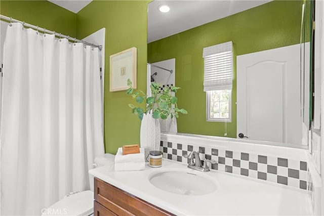 bathroom featuring toilet, vanity, a shower with curtain, and backsplash