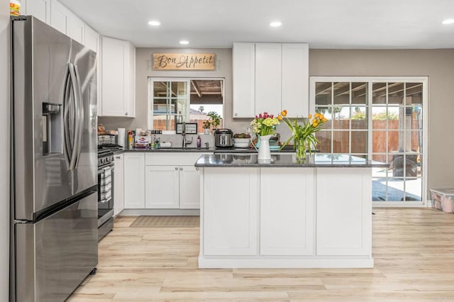 kitchen with a wealth of natural light, appliances with stainless steel finishes, a sink, and white cabinetry