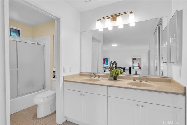 bathroom with tile patterned flooring, a sink, double vanity, and toilet
