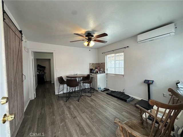 323 E 107th St, Los Angeles, CA 90003 - dining room featuring a barn door, a wall mounted air conditioner, wood finished floors, a ceiling fan, and baseboards