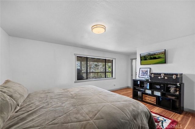 bedroom with baseboards and wood finished floors