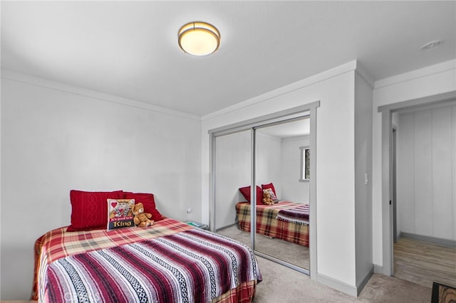 bedroom featuring carpet floors, a closet, crown molding, and baseboards
