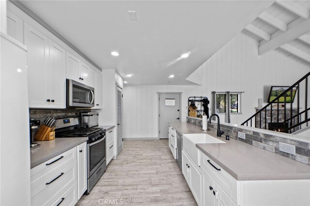 26429 Apache Trl, Rimforest, CA 92378 - kitchen featuring stainless steel appliances, white cabinets, tasteful backsplash, light wood-type flooring, and light countertops