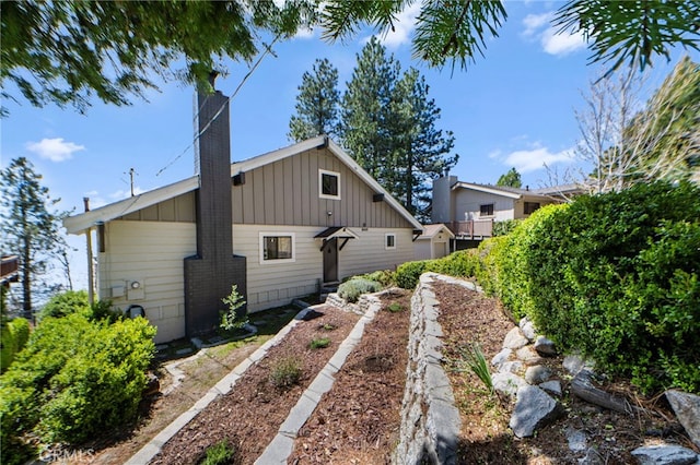 view of property exterior with board and batten siding and a chimney