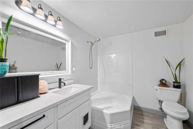full bathroom with washtub / shower combination, vanity, toilet, visible vents, and wood finished floors